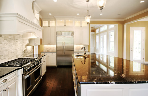Titanium Granite Countertop and Island Top with Nordic White Cabinets and White Carrara Marble Matchstick Backsplash and Dark Stained Flooring